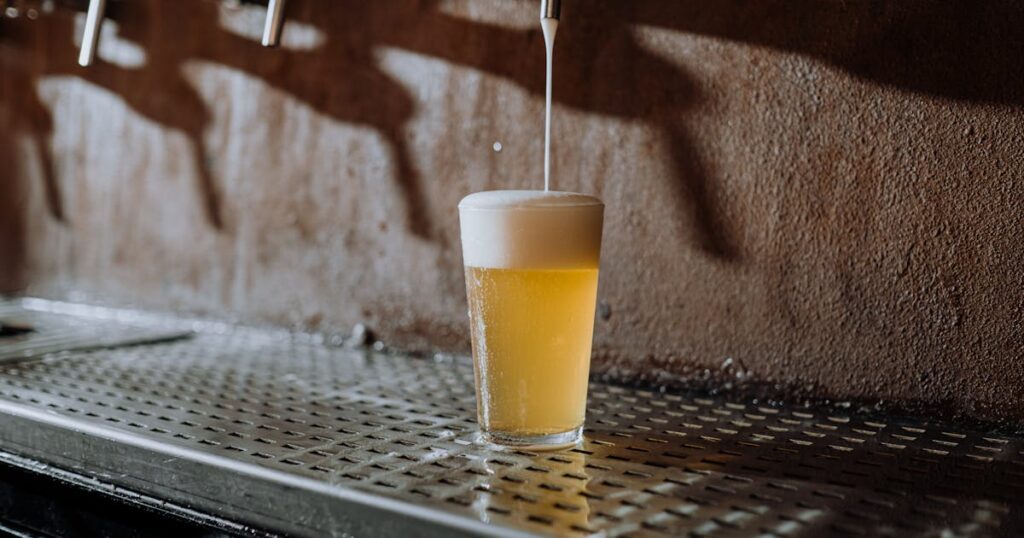 Low ABV beer pouring into glass with foam, representing 2026 brewing trend