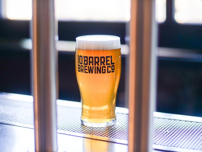 Golden craft beer with frothy head on a rustic wooden surface