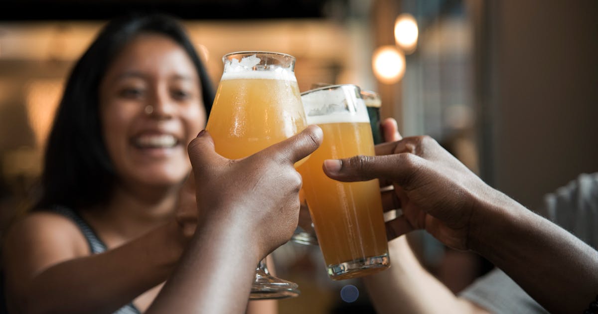 Glass of golden non-alcoholic beer with perfect white head on wooden table